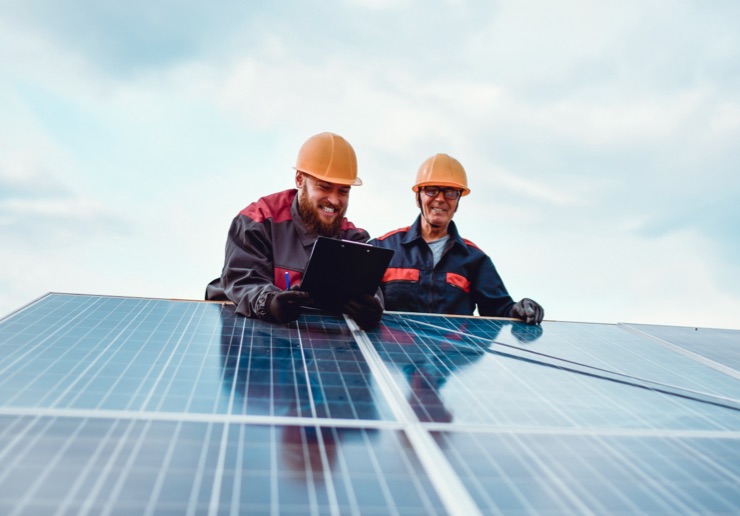 two people working on solar panels